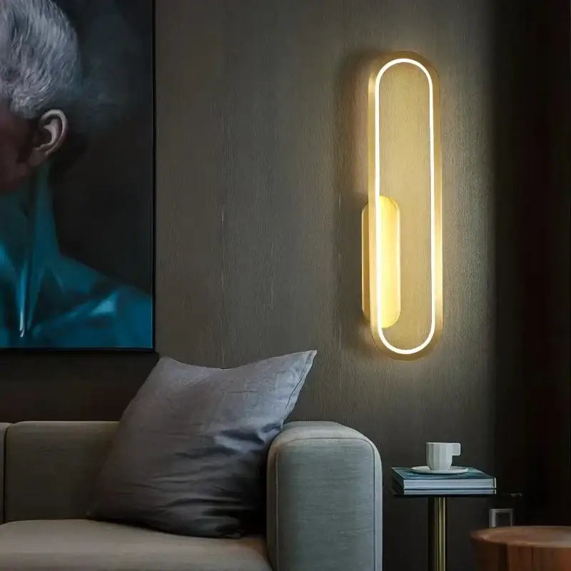Modern black and gold led indoor wall light with sleek elongated oval design and warm yellow decorbites black lighting