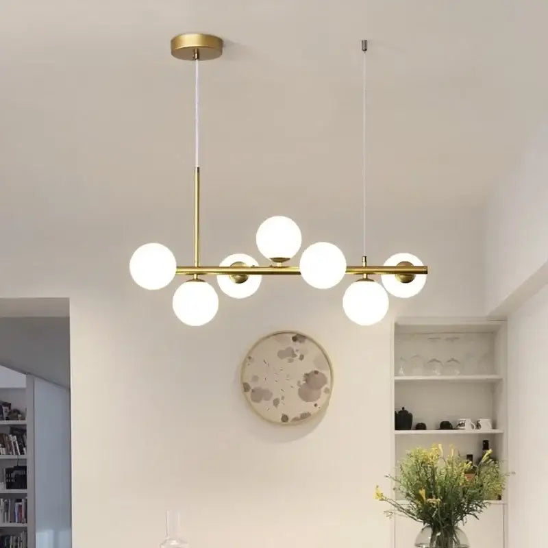 Modern black and gold led pendant chandelier with six white glass bulbs in a linear design for living room lighting