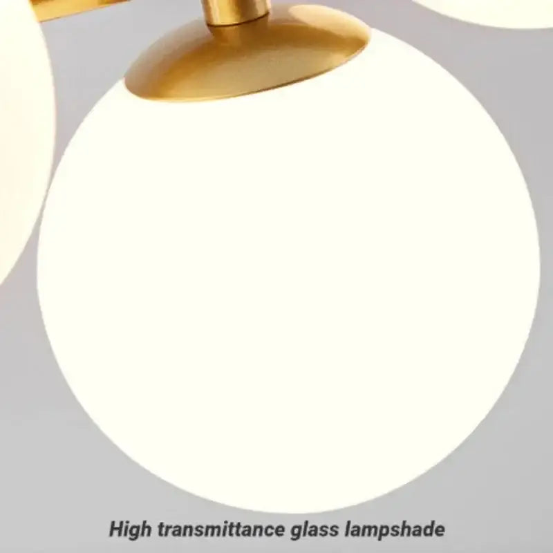 A modern black led pendant chandelier with a sleek round frosted white glass shade and polished brass top for living room