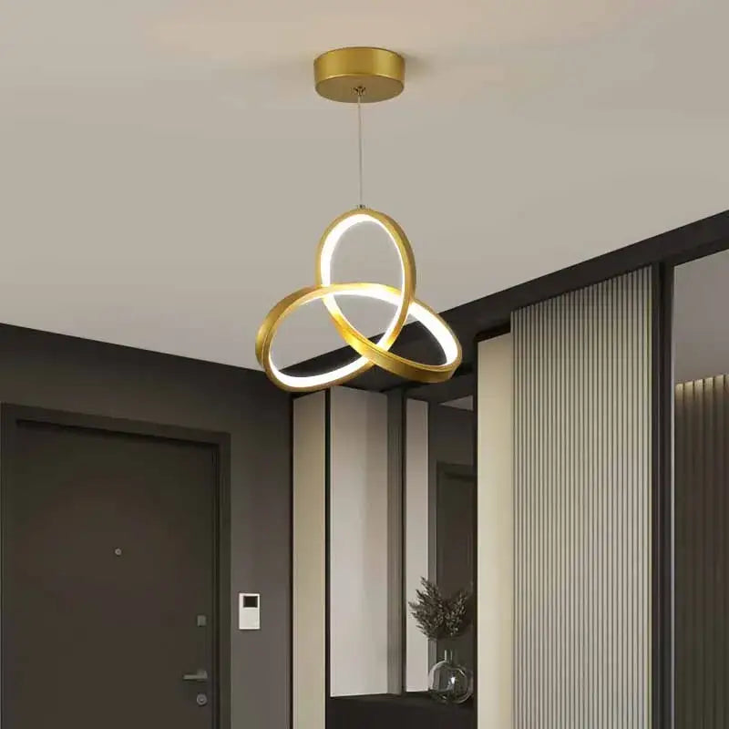 Modern black and gold led pendant light with three interlocking gold rings for dining room illumination