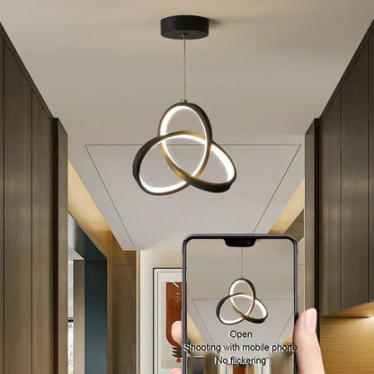 Modern black and white led pendant light with three interlocking circular rings for dining room lighting