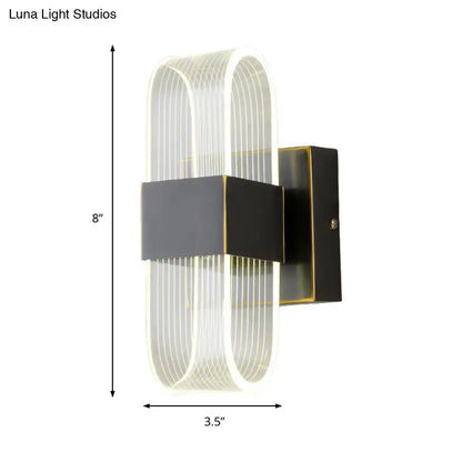 Modern black and gold sconce light with curved translucent acrylic body and vertical ridges for bedroom wall mount