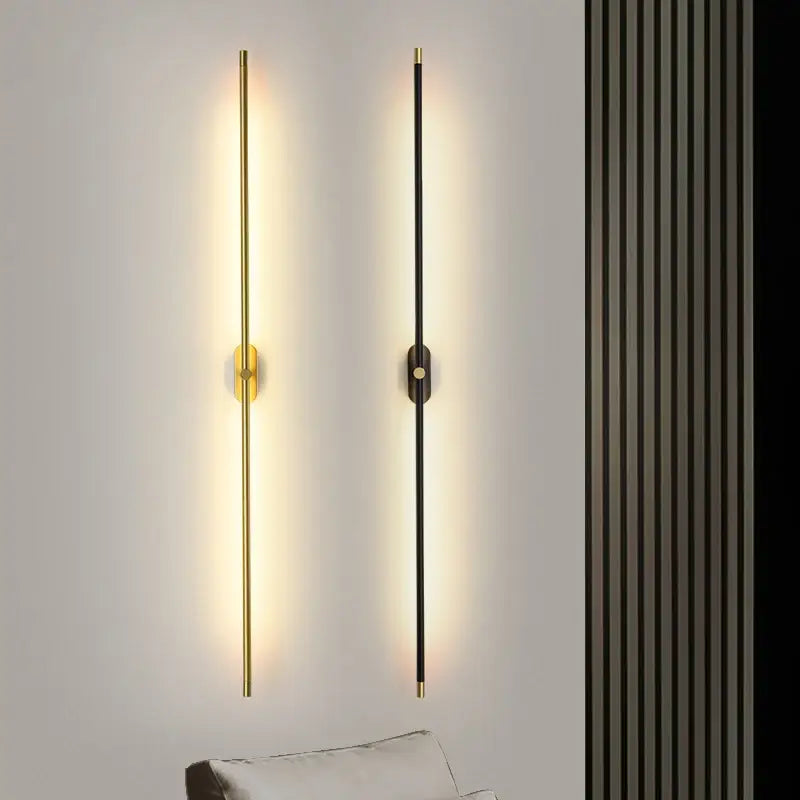 Two modern minimalist wall lamps with black and gold finishes featuring decorbites led strip vertical rods emitting warm light