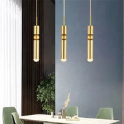 Three modern gold led tube pendant lights with black gold decorbites finish hang in kitchen setting