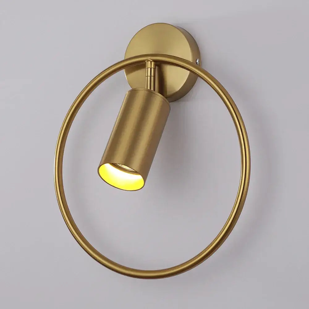 Brass-finished circular led wall lamp with cylindrical spotlight fixture in black and gold for living room and bedroom