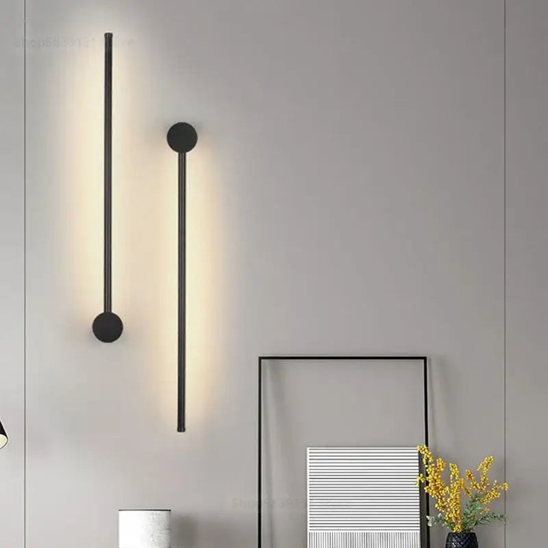 Modern black and gold minimalist wall lamps with cylindrical bodies emitting warm ambient glow for living room decorbites led wall lamps