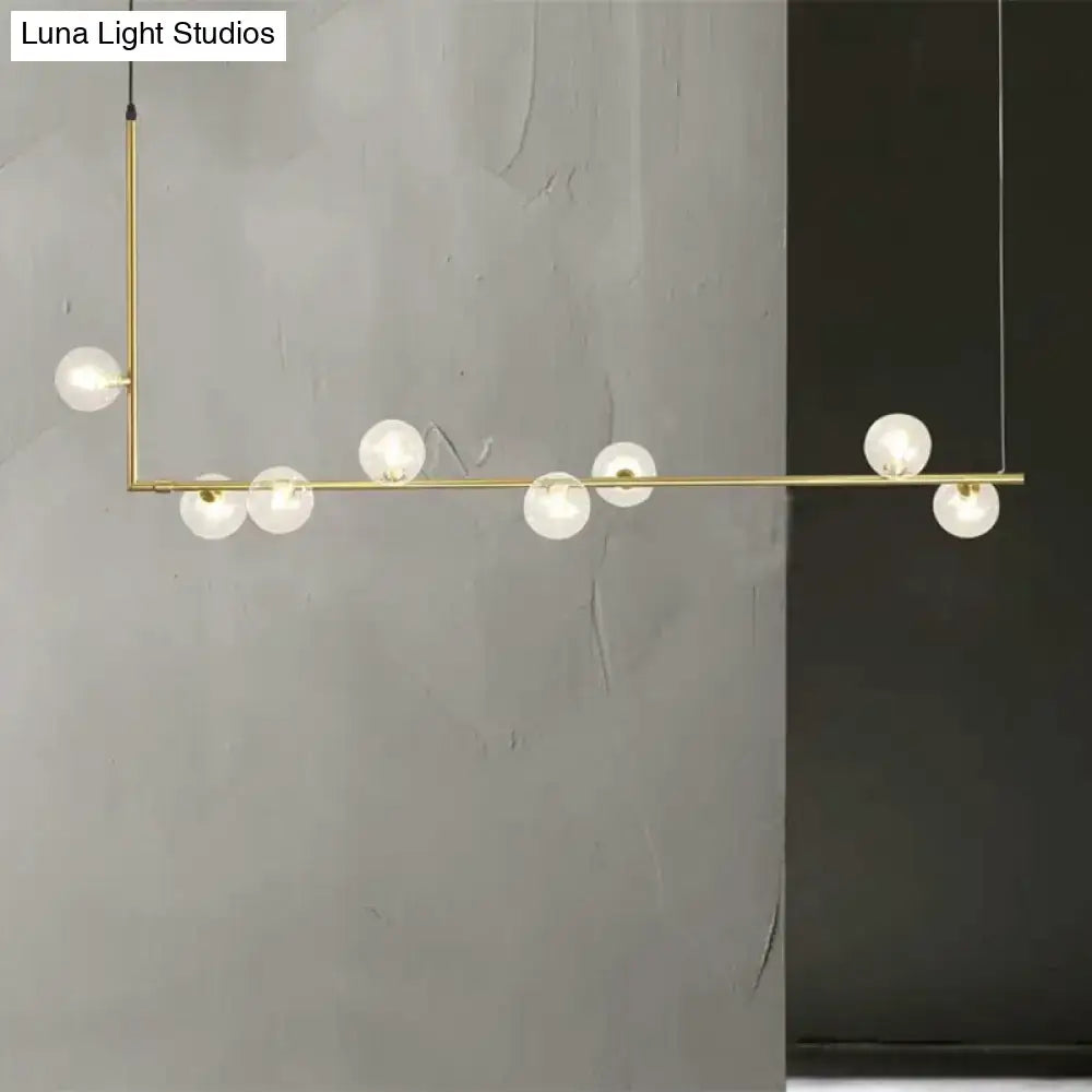 Modern black gold linear chandelier with seven frosted glass globe bulbs for dining room or island lighting