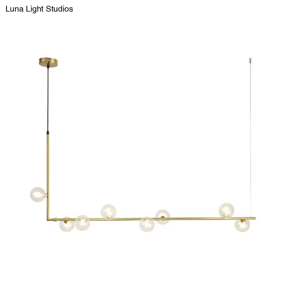 Modern black gold linear chandelier with gold-toned frame and clear glass globe bulbs for dining room island lighting