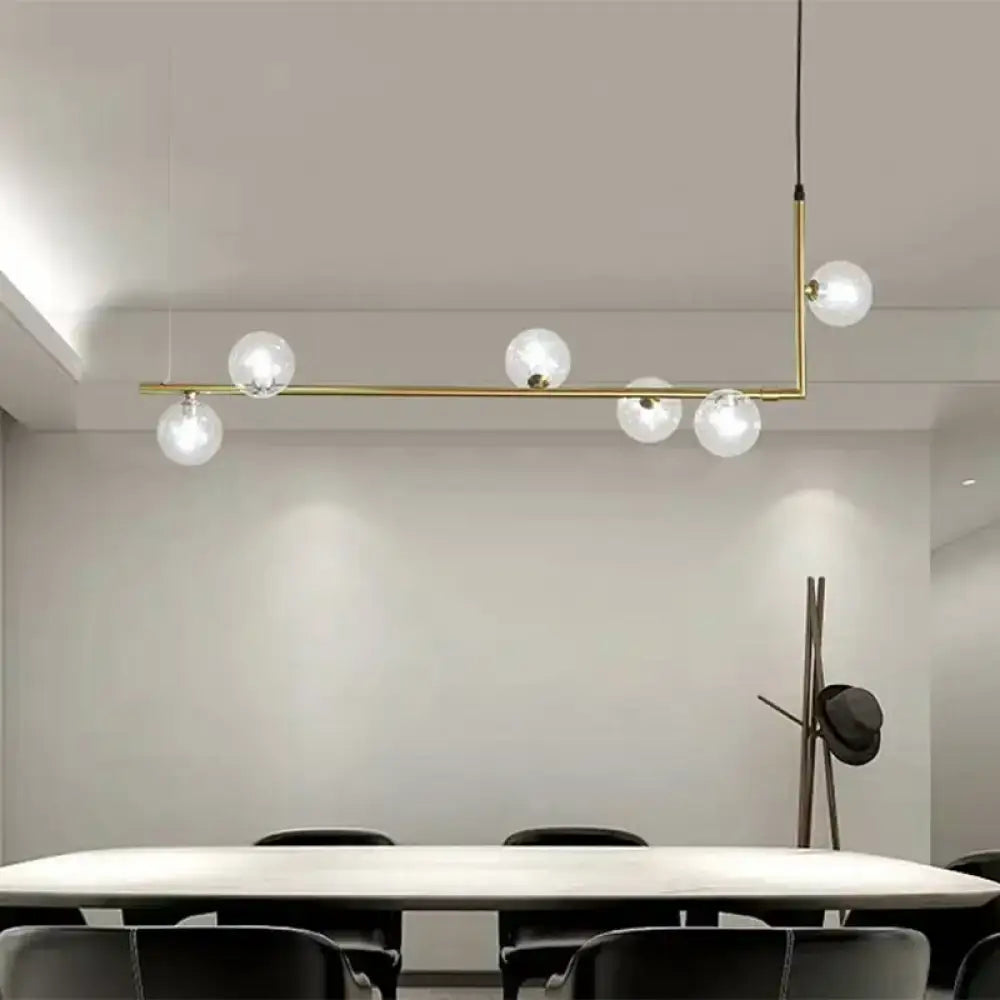 Modern black gold linear chandelier with five clear glass globe bulbs in a brass pendant light design for dining rooms