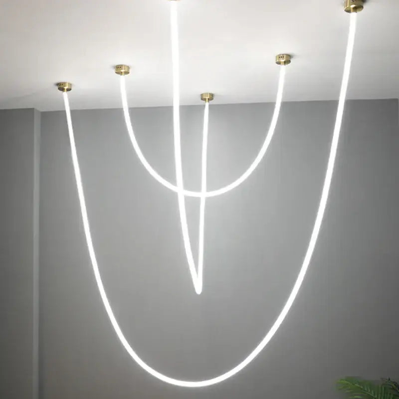 Modern black and gold linear pendant light with curved white led strands as a dining room light source