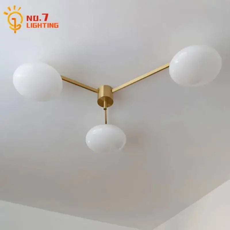Modern three-light ceiling light with gold lustre metal frame and frosted glass globes for kitchen use