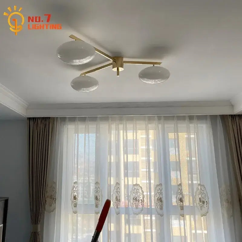 Modern black and gold lustre ceiling light fixture with brass finish and three frosted glass globe shades for kitchen use