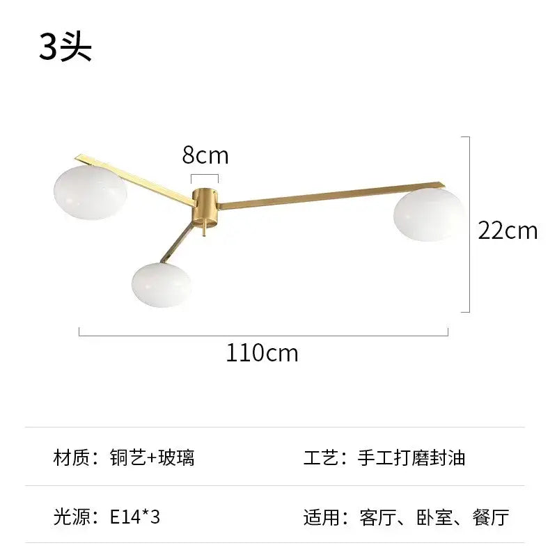 Modern black and gold lustre ceiling light fixture with three gold-toned arms and frosted glass globe shades for kitchen