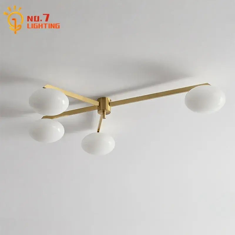Modern black and gold lustre ceiling light fixture with brass finish and four frosted glass globes for kitchen use