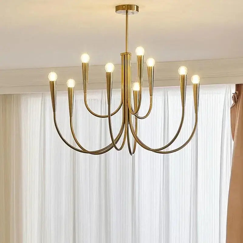 Modern black gold metal chandelier featuring sleek curved arms and exposed bulbs for dining room decorbites gold metal lighting