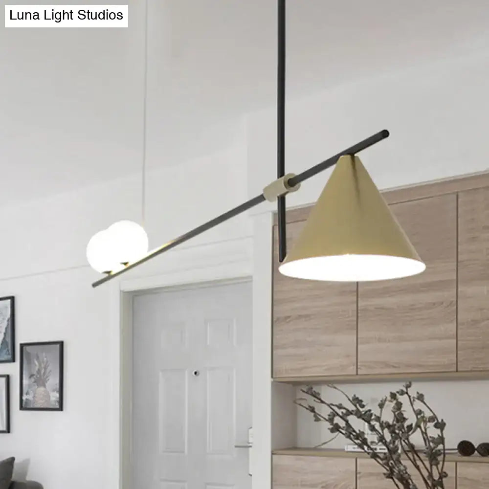 Modern black and gold metal cone island light with matte black arm and gold-toned conical shade for dining room