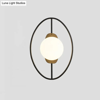 Modern black metal halo ring wall lamp with warm brass accent and white glass globe for bedroom lighting