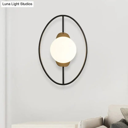 Modern black and brass metal halo ring wall lamp with frosted white glass globe for bedroom lighting