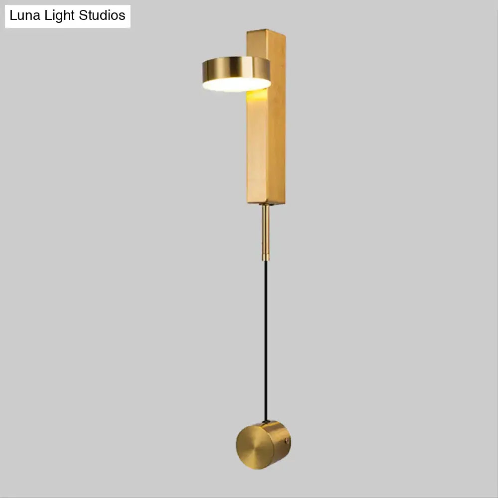 Modern black and gold metallic flush mount wall sconce with cylindrical light head and hanging spherical base for bedroom lighting