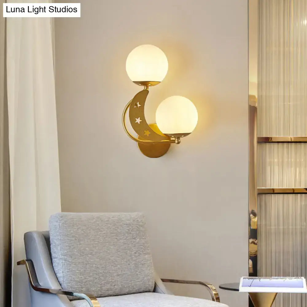 Gold-toned crescent moon wall lamp with star cutouts and two frosted milky glass ball shades for bedroom lighting
