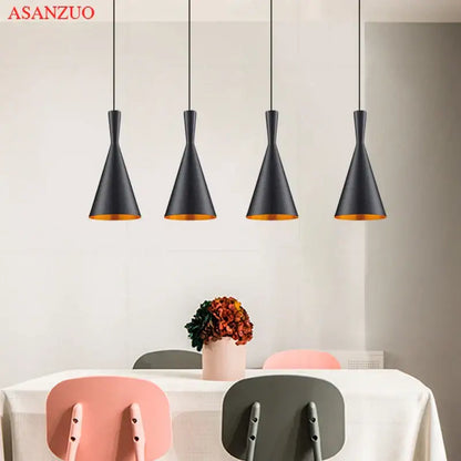 Four sleek black pendant lights with gold-lined interiors form a modern gold musical pendant light for dining room