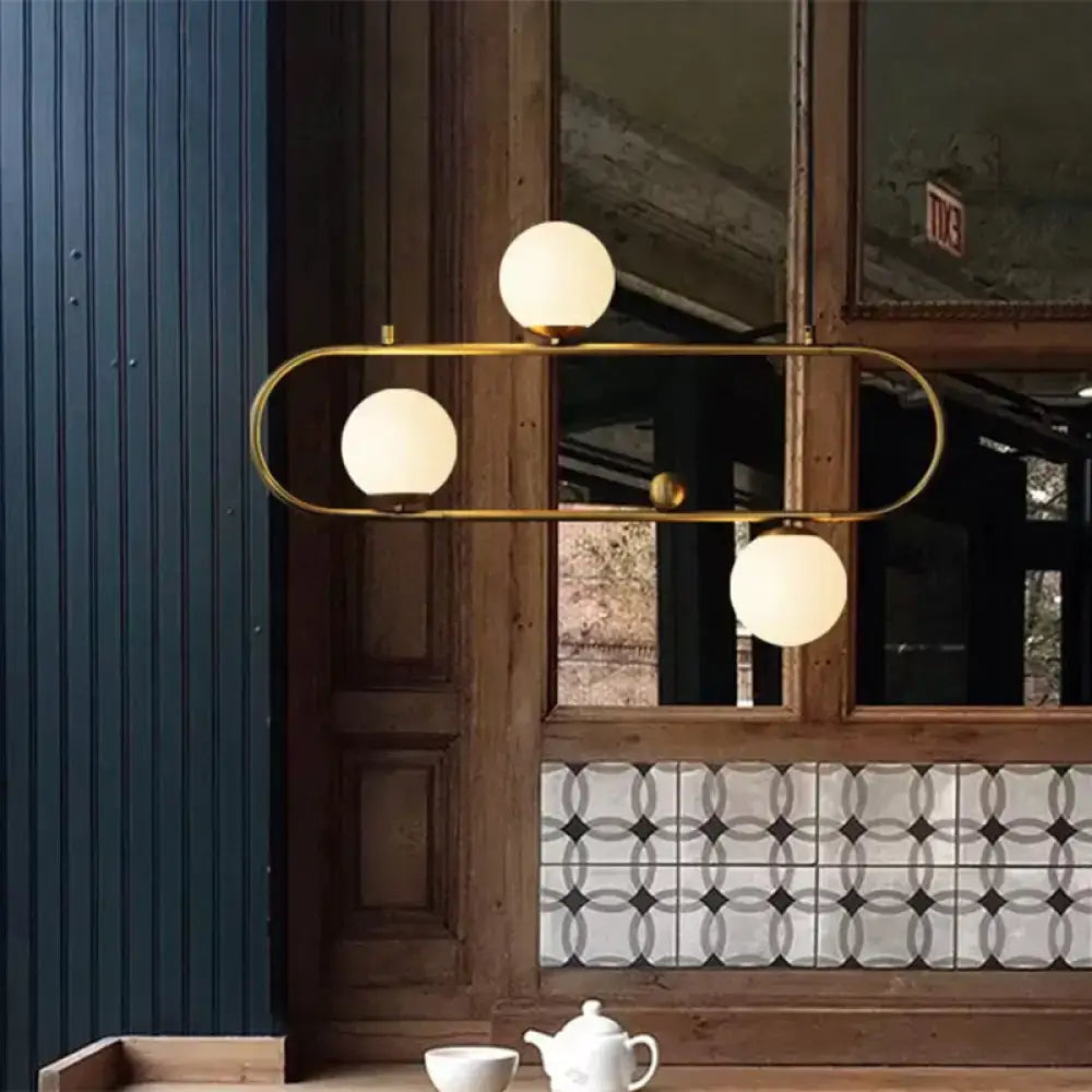 Gold-toned DecorBites modern oblong chandelier with three frosted opal glass globes black gold for dining room lighting