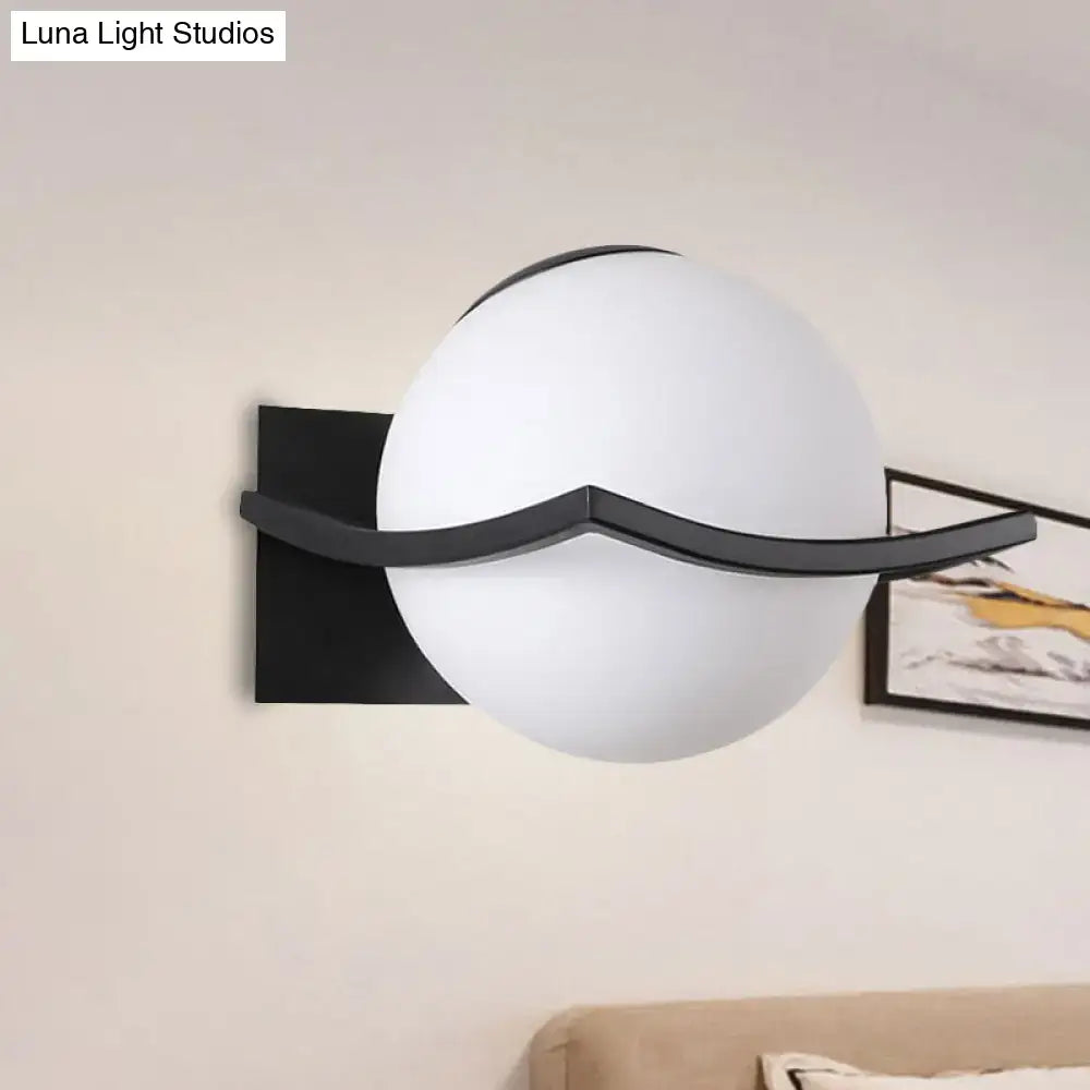 Modern black and gold opal glass globe wall sconce with sleek curved metal accent for bedroom led lighting