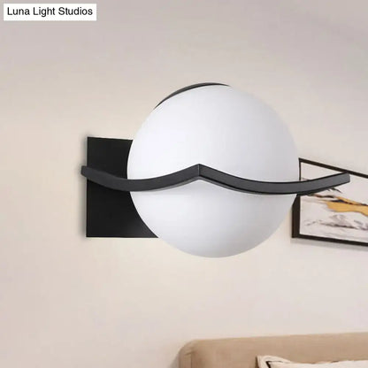 Modern black and gold opal glass globe wall sconce with sleek curved metal accent for bedroom led lighting