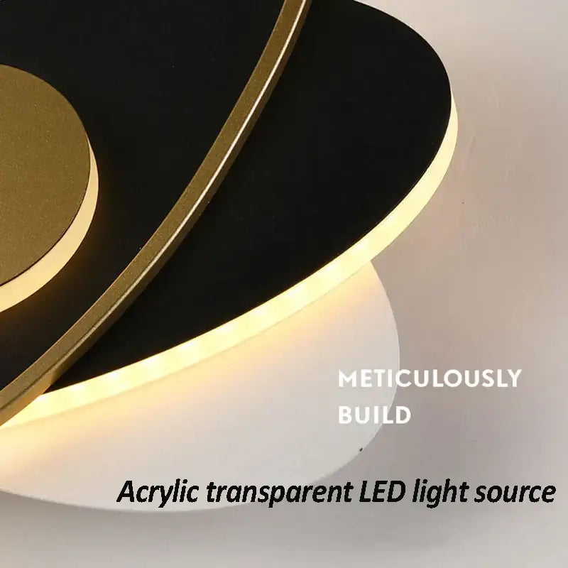 Modern black and gold orbital wall sconce light with sleek acrylic transparent led sconce light for living room