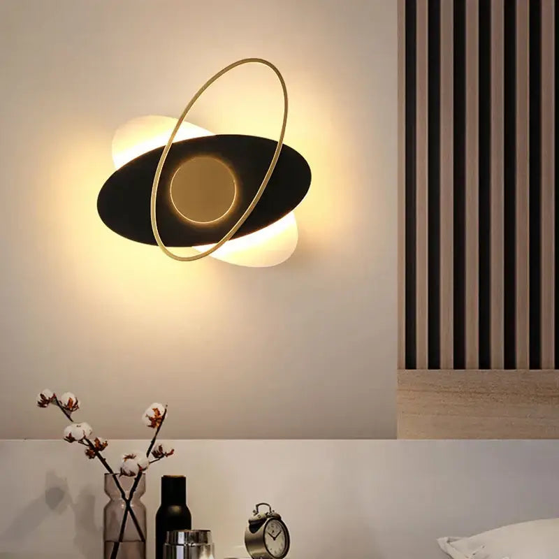 Modern black and gold oval wall sconce light with glowing circular accent for living room decor