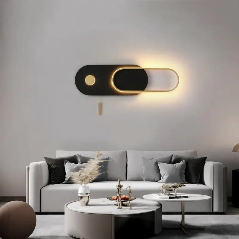 Modern black and gold oval led wall lamp with illuminated edges designed as a toggle-style bedroom sconce wall lamp