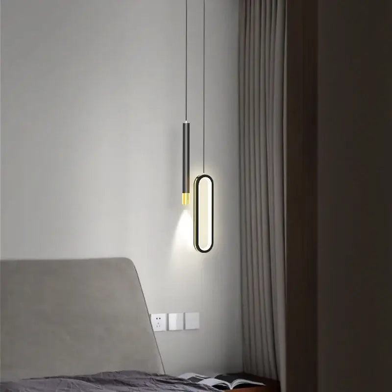 Modern black and gold oval pendant lamps feature a sleek black stem and warm gold base perfect for minimalist lighting