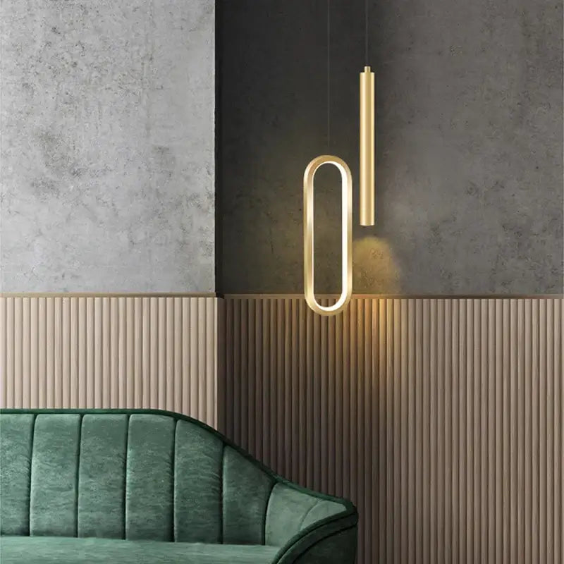 Modern black and gold pendant light with oval ring and vertical cylinder featuring white light source for dining room