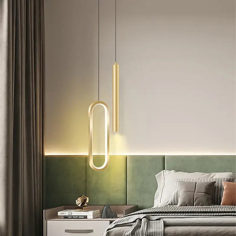 Modern black and gold pendant light with sleek oval frame and vertical cylinder, white light source for dining room
