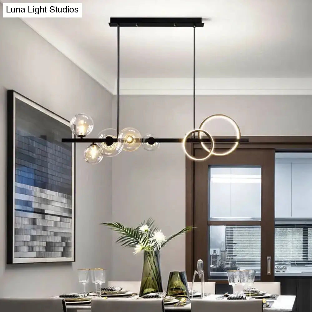 Modern black metal chandelier with clear glass spheres and glowing circular rings for dining room pendant light