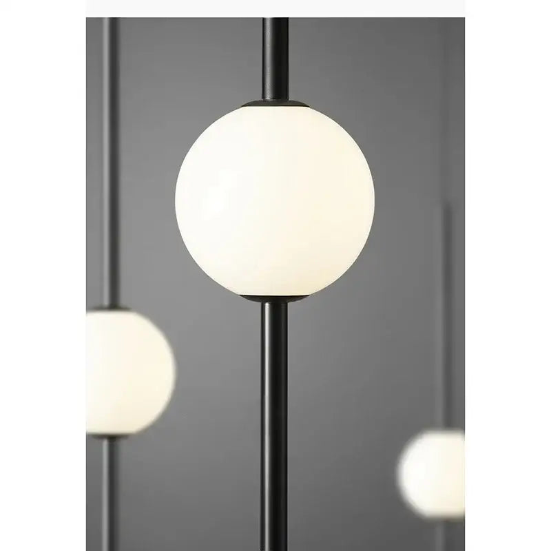 Modern black and gold pendant light with frosted glass shade for living room decor featuring a black metal pole