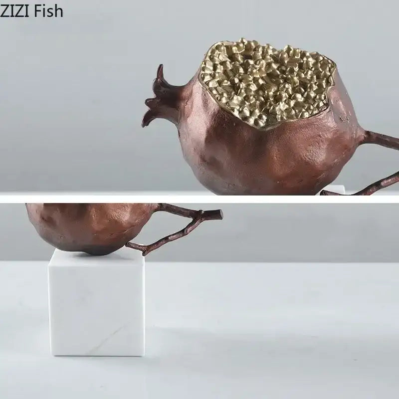 Modern black and gold golden pomegranate sculpture with textured interior and branch for living room decor by decorbites