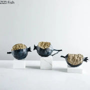Modern black and gold pomegranate sculpture set featuring decorbites golden pomegranate figurines on white marble bases