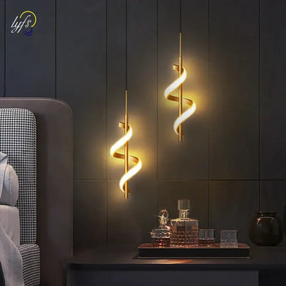 Two elegant black and gold spiral pendant lights with warm glowing illumination and copper lamp body for dining room