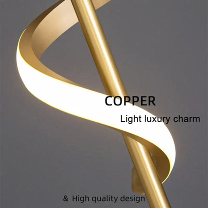 A modern black and gold pendant light with a spiraling copper lamp body and warm glow for dining room use