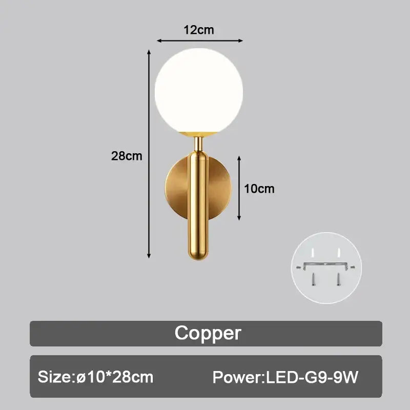 A sleek copper led wall sconce with a round frosted glass globe and cylindrical stem for modern bedroom lighting