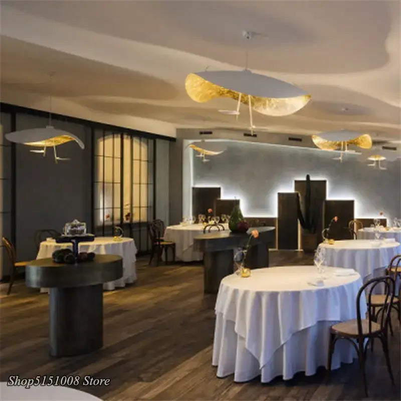 Elegant white and gold leaf-shaped pendant lights with decorbites gold texture led design illuminate a modern living room