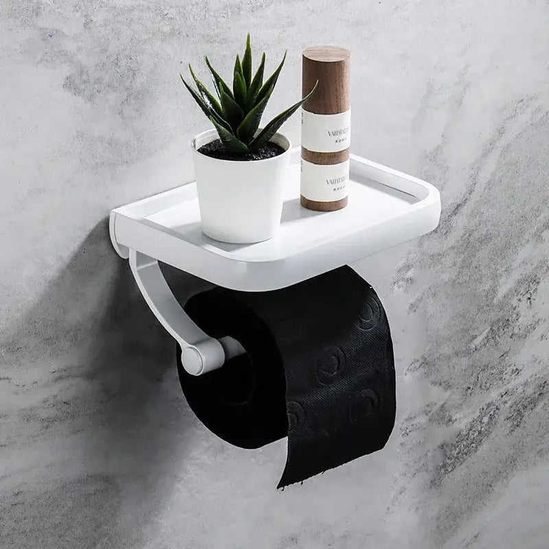 White plastic tissue paper holder with integrated shelf holding black patterned tissue paper and aloe vera plant