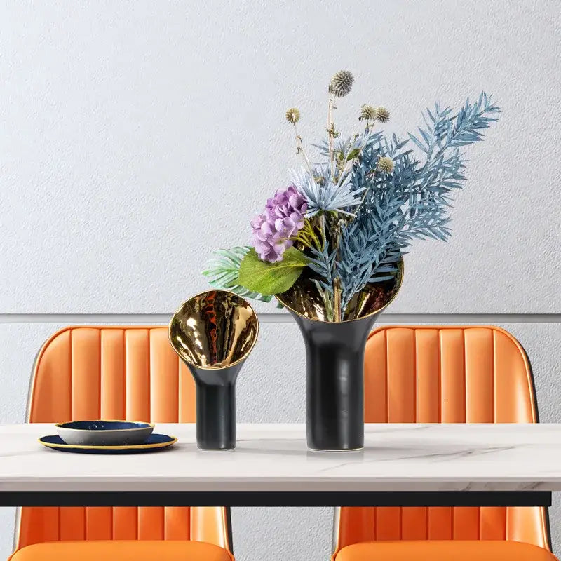Modern black and gold trumpet ceramic flower vase with flared opening holding purple hydrangeas and foliage decorbites golden trumpet