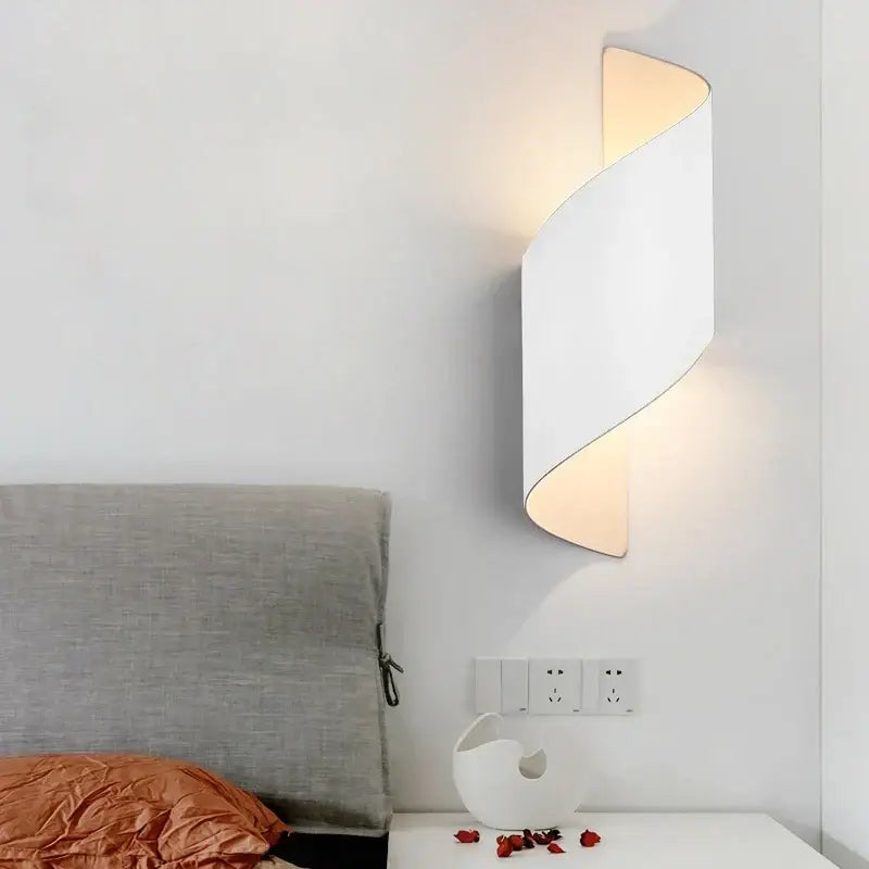 Modern black and gold twisted led wall lamp with sleek curved design emitting warm light for corridor use
