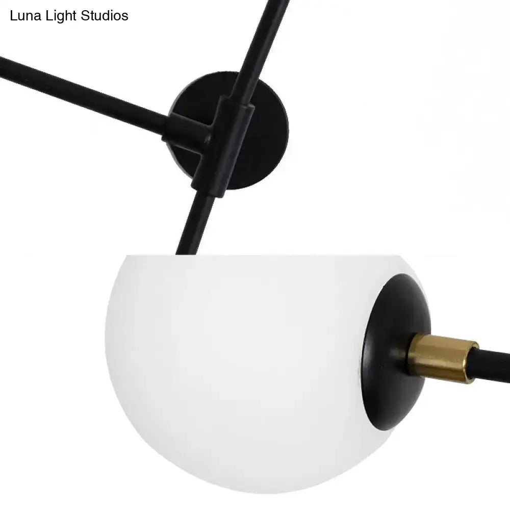 A modern design black metal wall lamp with brass accent and frosted glass globe direct wired electric sconce