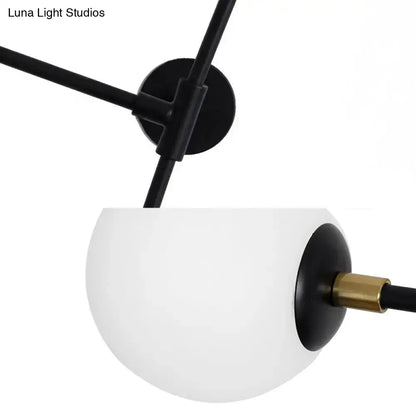 A modern design black metal wall lamp with brass accent and frosted glass globe direct wired electric sconce