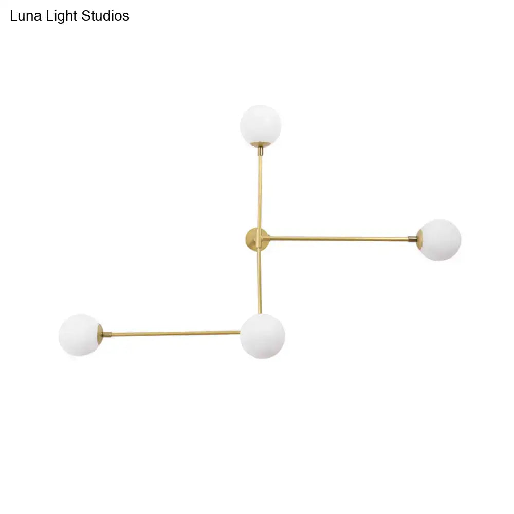 Gold-toned geometric chandelier wall lamp with four frosted glass globe shades in a modern design direct wired electric