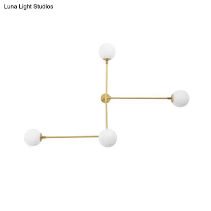 Gold-toned geometric chandelier wall lamp with four frosted glass globe shades in a modern design direct wired electric