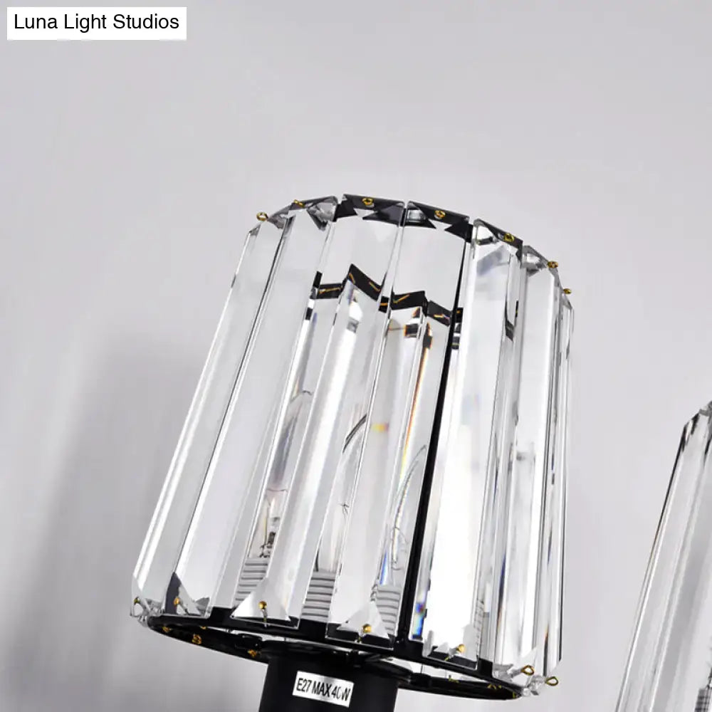Modern black and gold wall lamp with clear glass crystal shade featuring vertical facets and black metal frame for bedroom use